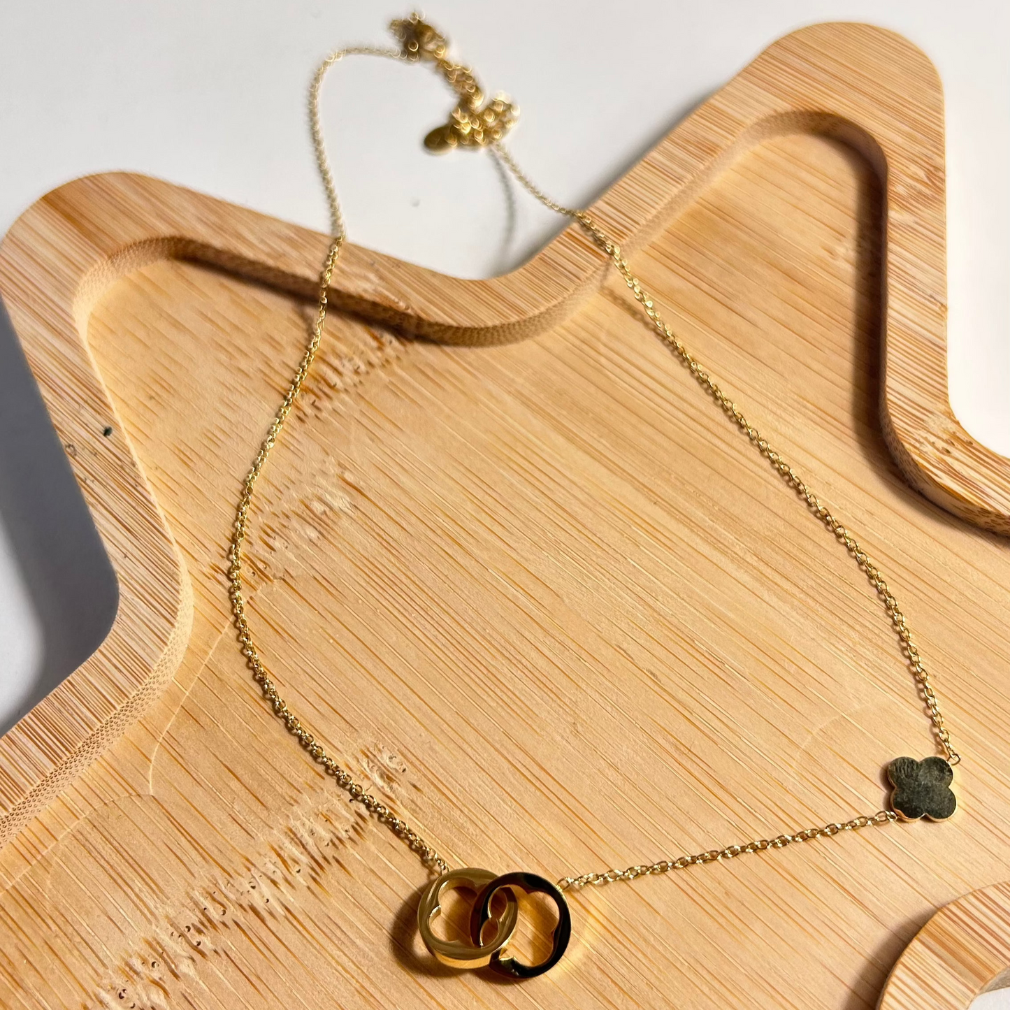 Collier MÉLINA – Deux trèfles entrelacés en acier inoxydable doré